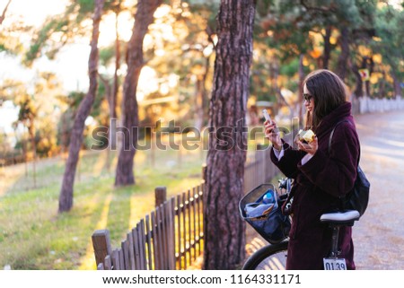 Beautiful young girl on a bicycle posing at the camera in the park
