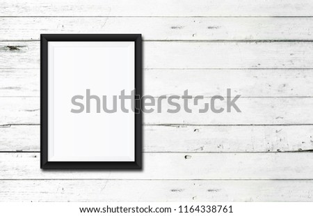 White poster Or a white picture frame hanging on the white wood wall background in the room.Have space for your message.