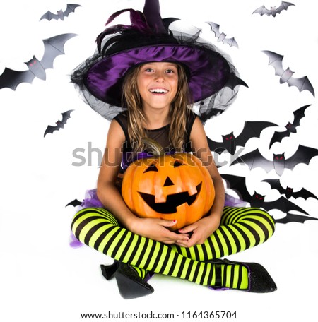 Happy scary girl   dressed up in halloween costume of witch, sorcerer  for pumpkin patch and halloween party . Halloween kids, 