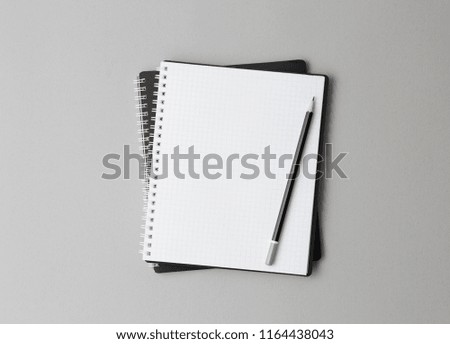 top view of a open black notebook with pencil on a gray background, school notebooks with a spiral spring, office notepad flat lay