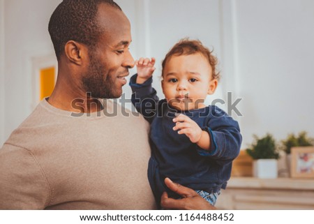 I love you. Content afro-american father smiling and holding his little son
