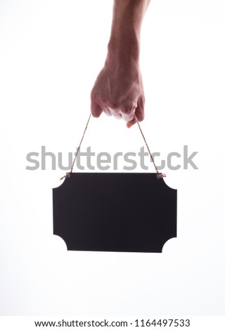 Male hand are holding hanged black empty chalkboard.