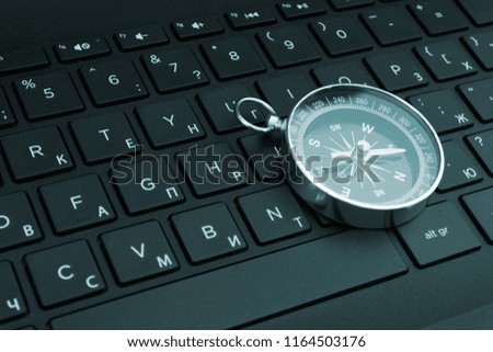 Laptop keyboard and compass, internet navigation concept