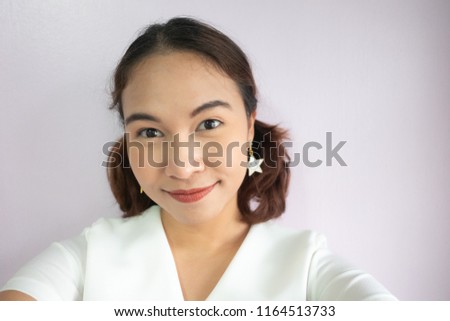 Portrait of a happy young attractive woman making selfie photo from her hands. Camera girl selfie concept.