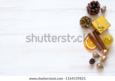 Winter background with Christmas decorations- gold  gift boxe, cones , dry orange and cinnamone. Top view. Copy space