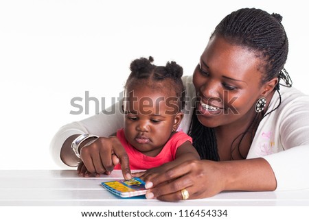The mother is teaching her daughter some alphabet letters.