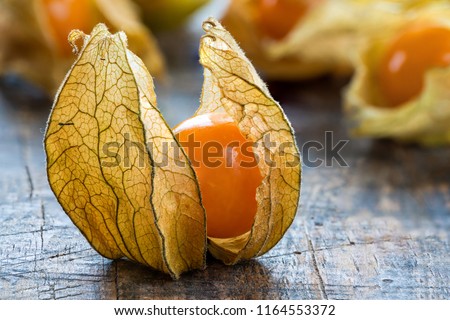 Physalis fruit (Physalis Peruviana) with husk on wooden background - closeup Royalty-Free Stock Photo #1164553372