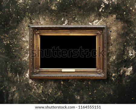 Old vintage gold ornate frame for picture on grunge stone wall