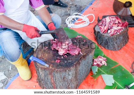 A picture of a man chop a cow backbone as part to make delicious soup in Malaysia.