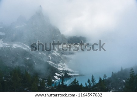 
Lake Sorapiss in the fog with amazing turquoise color of water. The mountain lake in the Dolomites. Italy