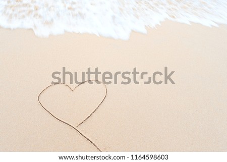Heart-shaped sand beach with sea waves splashing lightly is a picture of Valentines Day.