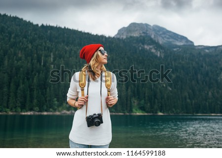 Travel photographer. Female backpacker at mountain. Hipster girl with camera
