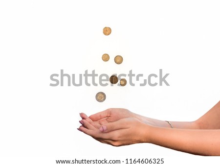 Female hands and some falling coins isolated on white background