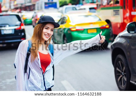 Tourists are calling a taxi in the Chinatown area of Bangkok, Thailand.