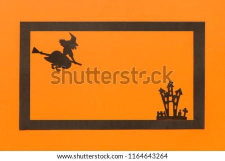 Halloween background. Black paper Witch and haunted house castle and black frame on orange background Happy halloween concept, space for text. Top view. Mockup, Layout Flat lay
