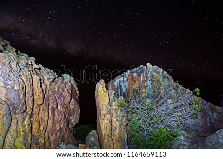 Rocks illuminated at night with starry sky
