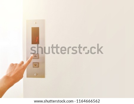 Businessman hand press open button to extend office building elevator doors with copy space for text