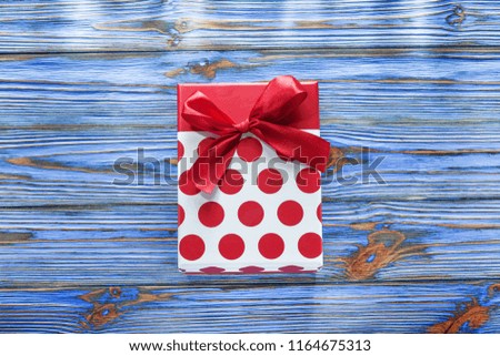 Red present box on vintage wooden board.