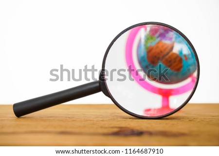 Travel And Adventure Object On The Wooden Grunge Table Background.  globe in Magnifying Glass