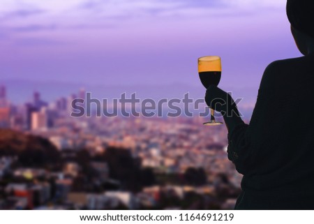 Female hand with glass of wine on  San Francisco city background. Service on the roof of the restaurant