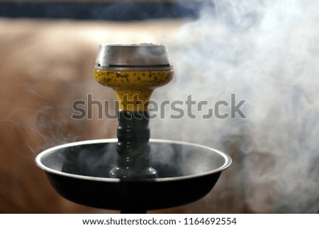 a bowl of hookah on the background of smoke