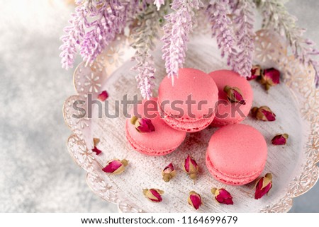 Pink macaroons on a vintage plate and dried flower buds. Pastel colored