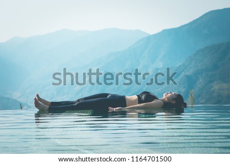 Beautiful Attractive Asian woman practice yoga Dead Body or Savasana on the pool above the Mountain peak in the morning in front of beautiful nature views in SAPA vietnam,Feel so comfortable Royalty-Free Stock Photo #1164701500