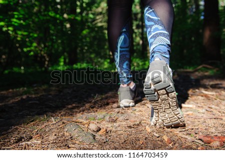 Girl in sneakers walking on a forest path, training