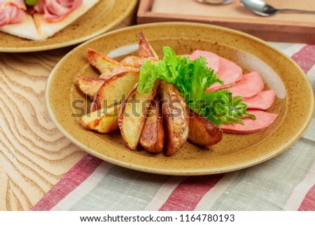 Roasted potatoes with ham slices close up