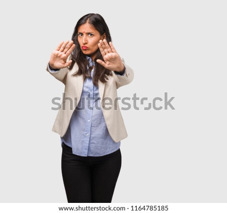 Young business indian woman serious and determined, putting hand in front, stop gesture, deny concept