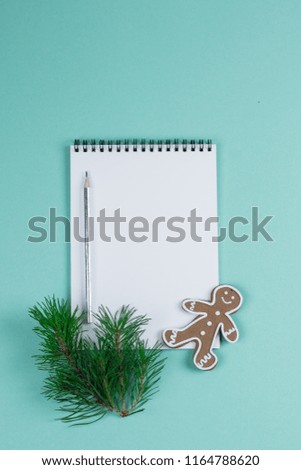 Christmas mock up blank greeting card. Fir tree branches and gingerbread over green paper background. Flat lay. Top view. Copy space