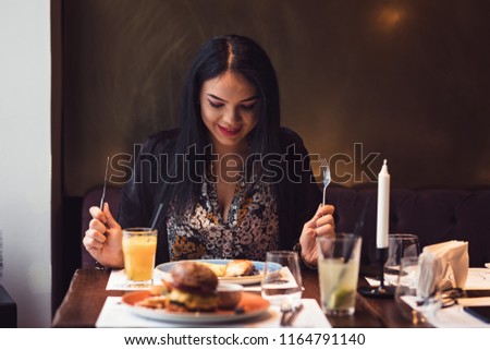 Pround woman looking at the steak and harburger she and her husband just made in their new kitchen