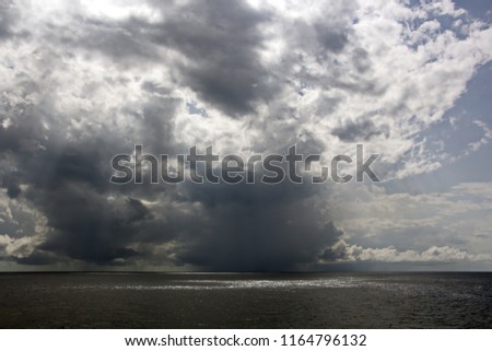 Before the storm. A painted view of storm and rain clouds and the sky above the sea horizon. View from the side of a sea ship while driving and in the port at anchor.