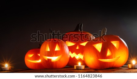 Halloween pumpkins head jack o lantern and candles on wooden background