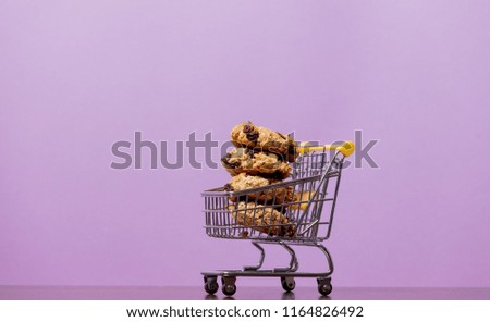 Christmas cookie inside supermarket cart in purple background