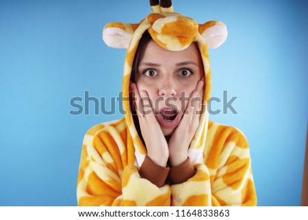 girl in a bright children's pajamas in the form of a kangaroo. emotional portrait of a student. costume presentation of children's animator. Slippers in the form of cat's paws.         