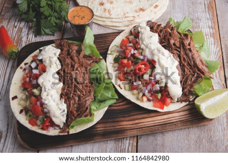 Mexican tacos with roasted beef ,sauce and salsa tomato