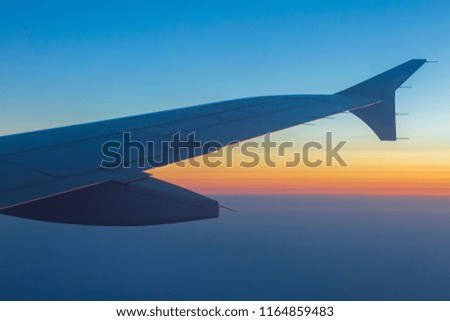 Wing of an airplane in the sunset. Airplane wing out of window.