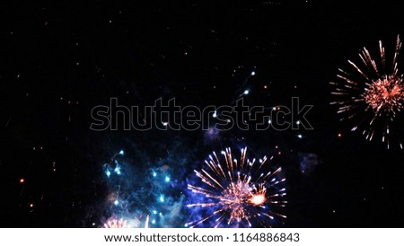 The color of the fireworks photographed in the closeup, the background photograph reminiscent of the universe