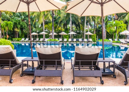 Beautiful luxury outdoor swimming pool with umbrella and chair in hotel and resort for travel and vacation