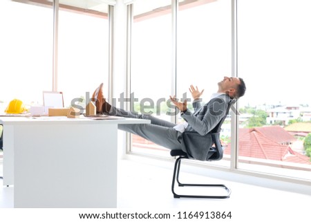 businessman or architecture or project manager sitting on chair with put legs on table as relaxing action for happy or successful or achievement concept