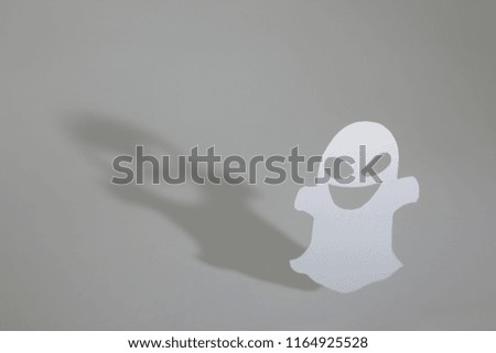 Halloween background decor holiday concept. Funny ghost and graphic shade, hard light on table.