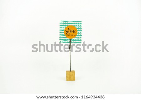 Label text "Shine today is your day" with small wooden block and steel clip isolated with white background.