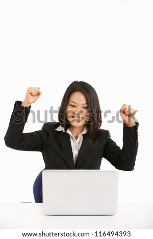 Studio Shot Of Chinese Businesswoman Working On Laptop And Celebrating