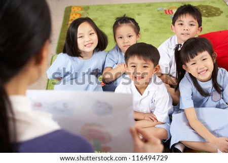 Teacher Showing Painting To Students In Chinese School Classroom