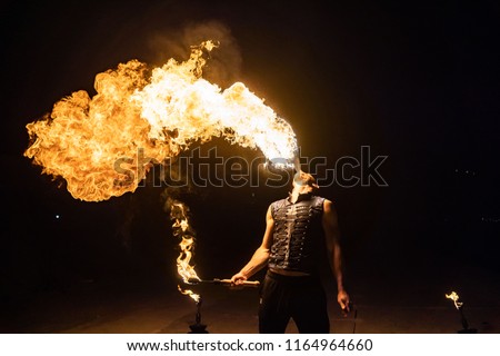 Fire show artist breathe fire in the dark jamp Royalty-Free Stock Photo #1164964660