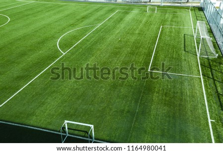 Empty football or soccer field with artificial grass or synthetic grass. Goal post and white lines penalty box. Royalty-Free Stock Photo #1164980041