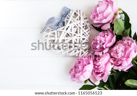 Pink peony flowers on a white wooden table