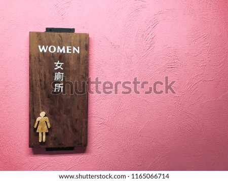 Women toilet sign on cement pink wall texture - can use to display or montage on product.
