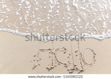 The text Hello morning writing on the sand beach by the sea, used in greeting